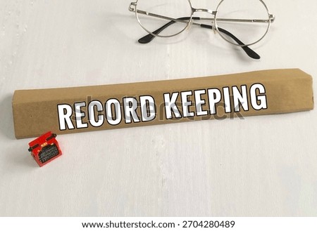 Typewriter model, spectacle and record keeping words on white wooden view background