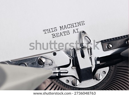 Typewriter typing THIS MACHINE BEATS AI on paper, symbolizing human creativity versus artificial intelligence or tradition versus progress.
