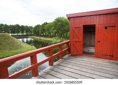 Typical 17th Century Dutch Street View In A Fortified Town With Historic Wooden Outhouse Or Toilet On Top Of The Defence Wall Above The Moat Or Canal