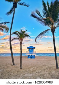 Typical american blue lifeguard house on Florida beach in Hollywood USA. Beautiful tropical Floridian landscape with tall palm trees, ocean and lifeguard house at sunset. Popular american landmark.