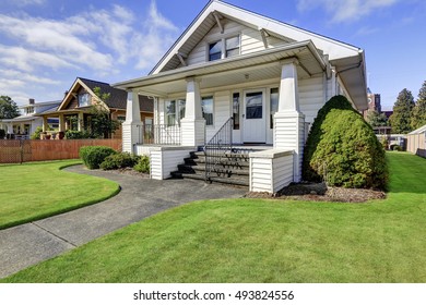 Typical American craftsman style house with column porch and well kept lawn. Northwest, USA