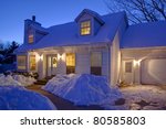Typical American home with icy winter snow - evening twilight - cape cod style