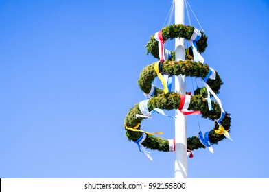 typical bavarian maypole in front of blue sky