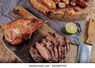 Typical Brazilian Barbecue With Tuscan Sausage, Chicken Sausage, Pork Prime Rib And A Piece Of Sliced Skirt Steak With A Slice Of Lemon On The Side.