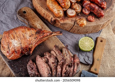 Typical Brazilian Barbecue With Tuscan Sausage, Chicken Sausage, Pork Prime Rib And A Piece Of Sliced Skirt Steak With A Slice Of Lemon On The Side.