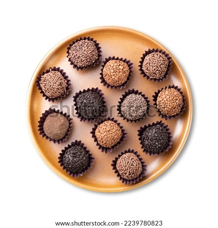 Typical brazilian brigadeiros, various flavors on a brown plate isolated over white background.