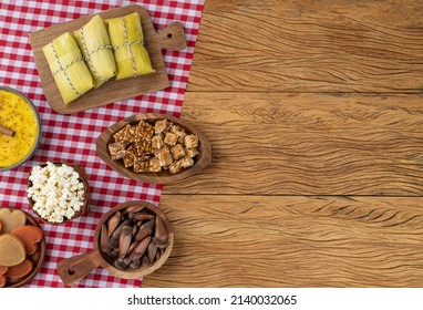 Typical brazilian june festival food over red plaid fabric with copy space. Festa junina. - Shutterstock ID 2140032065