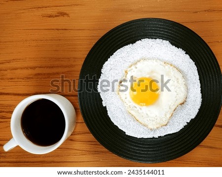 Typical Brazilian snack know as tapioca	with fried egg and mug of coffee on the wooden background