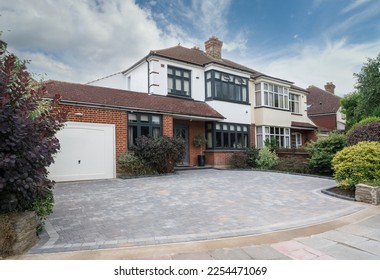 
Typical British semi-detached house in South East England, UK with grey anthracite windows and block paving driveway. - Shutterstock ID 2254471069