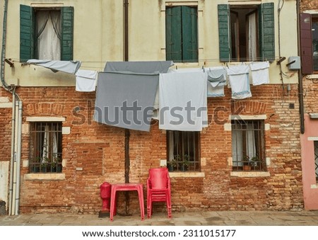 Typical city corner with ancient colorful buildings Drying clothes on a clothes-line in outdoor at sunny summer day. Venice, Italy