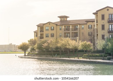 Typical Condo Apartment Homes Overlooking Community Lake With Fountain Spray. Downtown Skyline In Background Las Colinas, Irving, Texas, America.