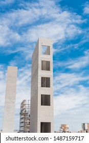 Typical Construction Site Of New Condominium Building In Texas, America With Elevator Shaft And Metal Scaffolding System. Looking Up View Of Concrete Elevator Tower Under Cloud Blue Sky