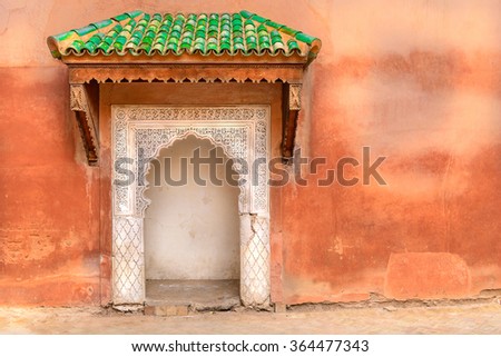 Typical decorated Moroccan door with green roof and ethnic handmade decoration.  
Rough wall with small multicolor port entrance in Arabic style decoration. Concept of 
freedom to travel around world.