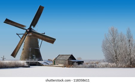 Typical dutch windmill and an old shack in the winter
