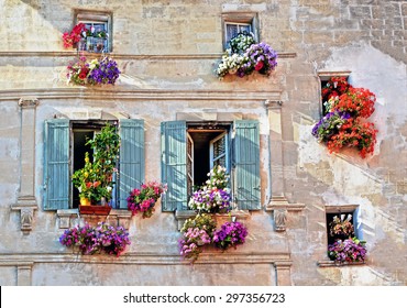 Typical facade of the old Provencal retro house with windows and wooden shutters decorated with colorful fresh flowers in Provence, Cote d'Azur, France - Powered by Shutterstock