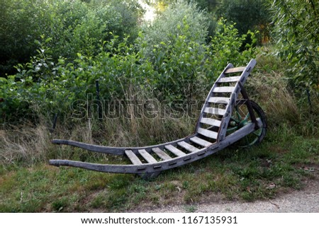 Image, Stock Photo Holzpaddel lehnt, halb von der Trauerweide bedeckt, an der sonnenwarmen Steinmauer.