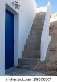 A Typical House Entrance In The Aegean Island Of Santorini, Greece, With A Blue Door And A Small Staircase And No People. Taken At The End Of A Sunny Summer Day.