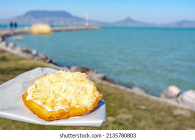 typical hungarian lake Balaton food langos with lake background in Fonyód - Shutterstock ID 2135780803
