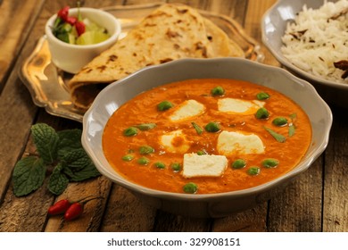 Typical Indian Meal -Paneer Curry Roti And  Rice On Wooden Surface