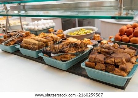 Typical Israeli breakfast buffet at any hotel.  Jachnun or Jahnun, Yemenite Jewish pastry, served with fresh grated tomato and boiled egg and Zhug
