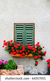 Typical Italian Window With Closed Wooden Shutters, Decorated With Fresh Flowers