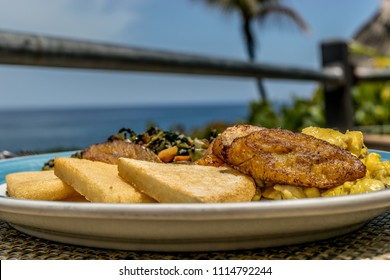 Typical Jamaican breakfast of fried bammy, friend plantain, ackee and saltfish/ salt fish/ codfish/ cod fish/ salted cod/ baccala, callaloo. These foods are also eaten for lunch or dinner.