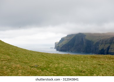 Typical Landscape On The Faroe Islands, With Green Grass And Cliff On The Northern Edge Of Eysturoy