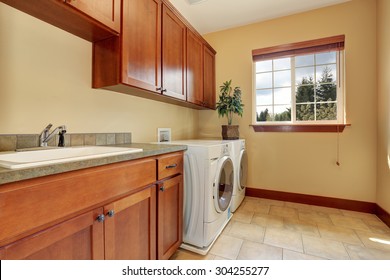 Typical Laundry Room With Nice Counter Tops And A Tile Floor.