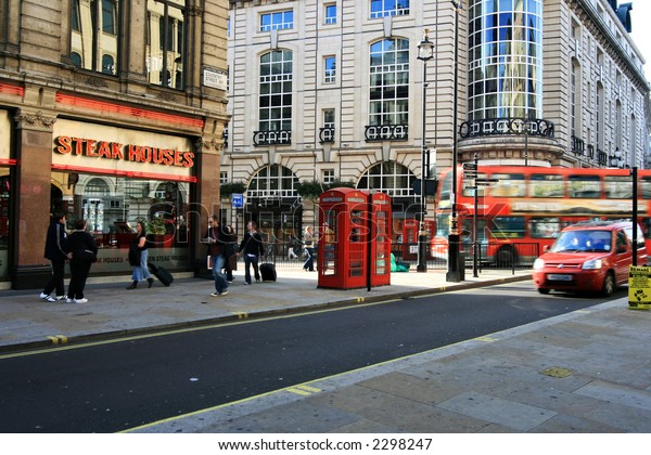 Typical London street with steak\
house, red telephone booth and double-decker bus,\
UK