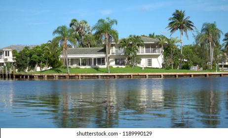 Typical Luxury Vacation Summer Home Exterior Establishing Shot Photo During Day Time. Generic Large Expensive Real Estate Mansion Along Coastal Waterway River