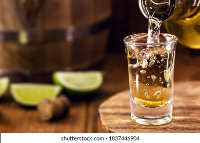 typical mexican drink bottle filling a glass of mezcal (or mescal), a rare mexican distilled beverage that contains an aphrodisiac larva or worm inside - Shutterstock ID 1837446904