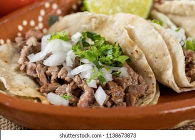 Typical Mexican food dishes with sauces on colorful table. Roast beef tacos