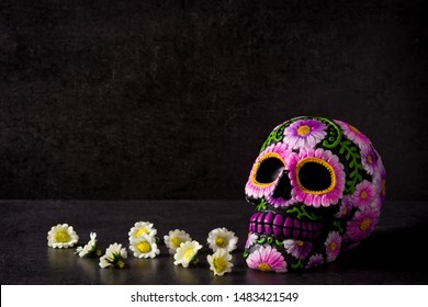 Typical Mexican skull painted and flowers on black background.Copy space. Dia de los muertos.