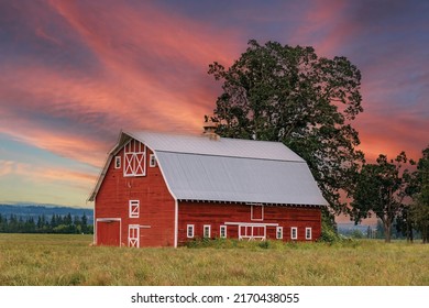 Typical Middle America Red And White Wooden Barn With Beautiful Colorful Sunrise Sky.