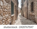 Typical narrow European village of Frontone street with sun on one side and shadow on other Italy, countryside, towns  ruins.