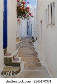 Typical narrow lane in Chora, Ios with whitewashed walls and blue doors.