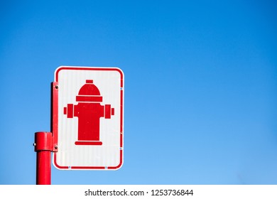 Typical North American  road sign indicating the presence of a fire hydrant taken in a street of Montreal, Quebec, Canada, with its typical red icon, during a sunny afternoon

