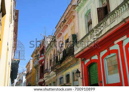 a typical old house in colonial style on central Havana, Cuba, wet clothes are drying in the wind, hanging in the balcony - a common scene in the streets of Havana