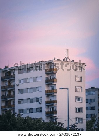 Typical old panel apartment block of flats with a lot of windows in Budapest, Hungary, communist era housing crisis rental prices, sunset dusk
