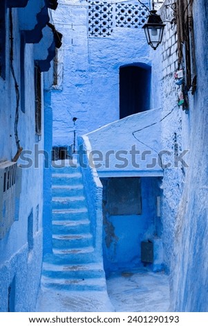 Typical old street with blue painted walls, stairs and doors in the medina of Chefchaouen, Morocco