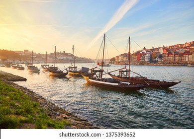 Typical portuguese wooden boats, called "barcos rabelos" transporting wine barrels on the river Douro with view on Villa Nova de Gaia  in Porto, Portugal