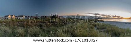 Typical resort landscape on the baltic sea  with the beach, dunes, pier hotels and holiday homes. Sunset by Heiligenhafen, Schleswig-Holstein, Germany