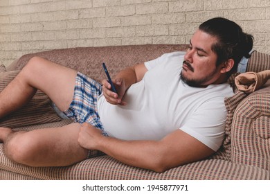 A typical slacker and bum with no ambition laying on the couch all day addicted to games, browsing or social media.