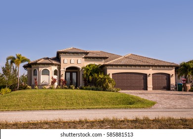 Typical Southwest Florida concrete block and stucco home in the countryside with palm trees, tropical plants and flowers, grass lawn and pine trees. Florida. South Florida single family house