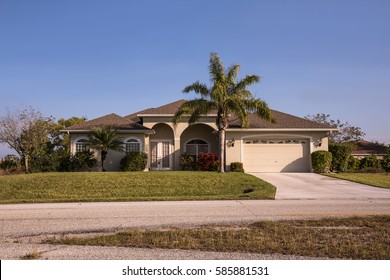 Typical Southwest Florida Concrete Block And Stucco Home In The Countryside With Palm Trees, Tropical Plants And Flowers, Grass Lawn And Pine Trees. Florida. South Florida Single Family House