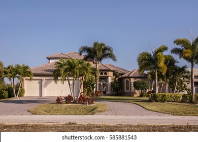 Typical Southwest Florida Concrete Block And Stucco Home In The Countryside With Palm Trees, Tropical Plants And Flowers, Grass Lawn And Pine Trees. Florida. South Florida Single Family House