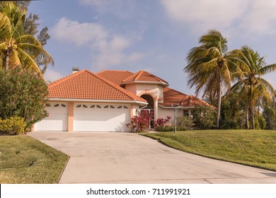 Typical Southwest Florida Concrete Block And Stucco Home In The Countryside With Palm Trees, Tropical Plants And Flowers, Grass Lawn And Pine Trees. Florida. South Florida Single Family House