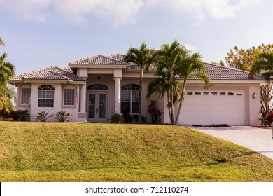 Typical Southwest Florida Concrete Block And Stucco Home In The Countryside With Palm Trees, Tropical Plants And Flowers, Grass Lawn And Pine Trees. Florida. South Florida Single Family House