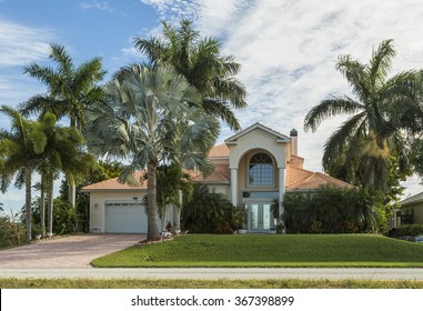 Typical Southwest Florida Home In The Countryside With Palm Trees, Tropical Plants And Flowers, Grass And Pine Trees. Inlaid Pavement At The Entrance. Florida