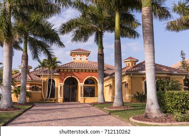 Typical Southwest Florida Luxury Concrete Block And Stucco Home In The Countryside With Palm Trees, Tropical Plants And Flowers, Grass Lawn And Pine Trees. Florida. South Florida Single Family House